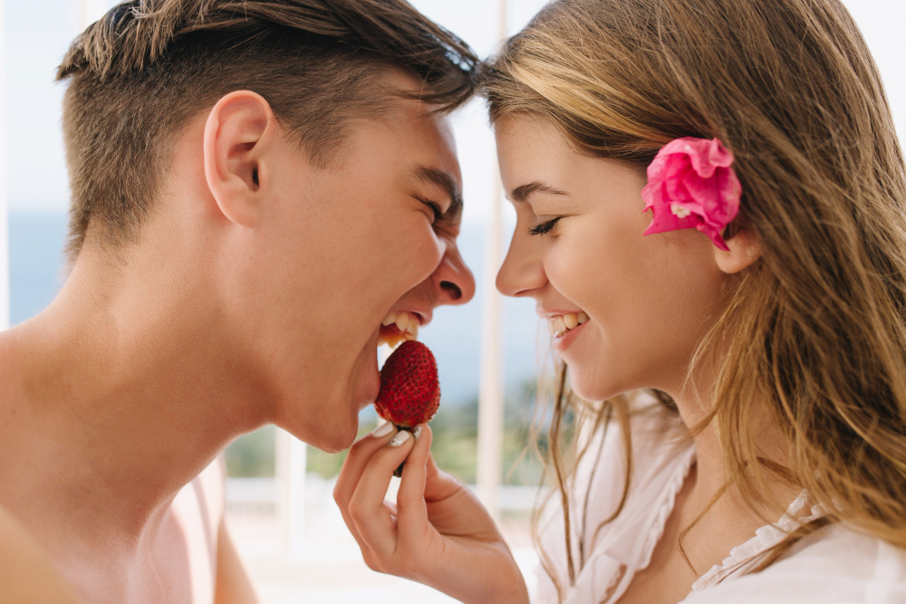 парень и девушка едят клубнику